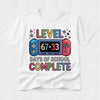 A white short-sleeve t-shirt with a colorful graphic on the front that reads 'LEVEL 67+33 DAYS OF SCHOOL COMPLETE' with a game controller illustration, shown on a light gray background.