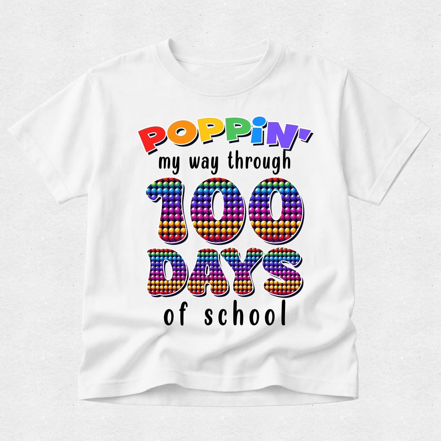 A white short-sleeve t-shirt with a colorful graphic that reads 'POPPIN' my way through 100 DAYS of school' on a light gray background.