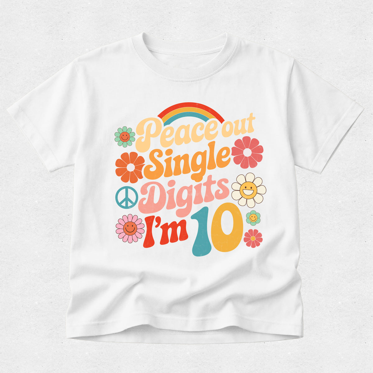 A white short-sleeve crewneck t-shirt featuring a colorful retro 1960s-style graphic that reads 'Peace out Single Digits I'm 10' with flowers, peace signs, and a rainbow.