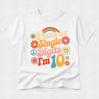 A white short-sleeve crewneck t-shirt featuring a colorful retro 1960s-style graphic that reads 'Peace out Single Digits I'm 10' with flowers, peace signs, and a rainbow.