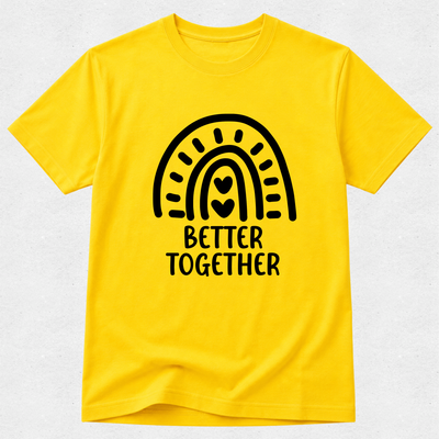 A bright yellow short-sleeve t-shirt with a black graphic of a rainbow arching over the words 'BETTER TOGETHER' in a rounded block font. The t-shirt is displayed flat against a light gray textured background.