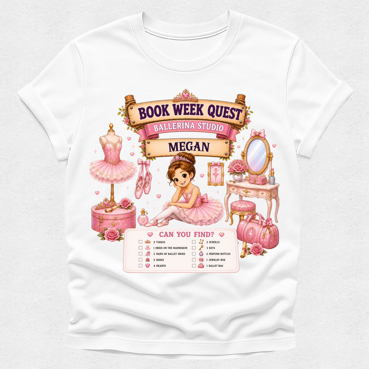 A white short-sleeve crewneck t-shirt featuring a detailed pink graphic print for a 'Book Week Quest' ballerina studio theme, with a checklist at the bottom and the name 'Megan' printed on a banner.