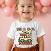 Child wearing a 'Wild One' t-shirt with a safari design on a pink background
