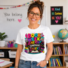 Person wearing a 'Book Week Energy Symphony Stories' t-shirt in a classroom setting