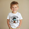 Child wearing a white t-shirt with a cowboy design and text on a beige background