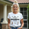 Woman wearing a white t-shirt with 'this awesome GRANDMA belongs to' text and three small images of children.