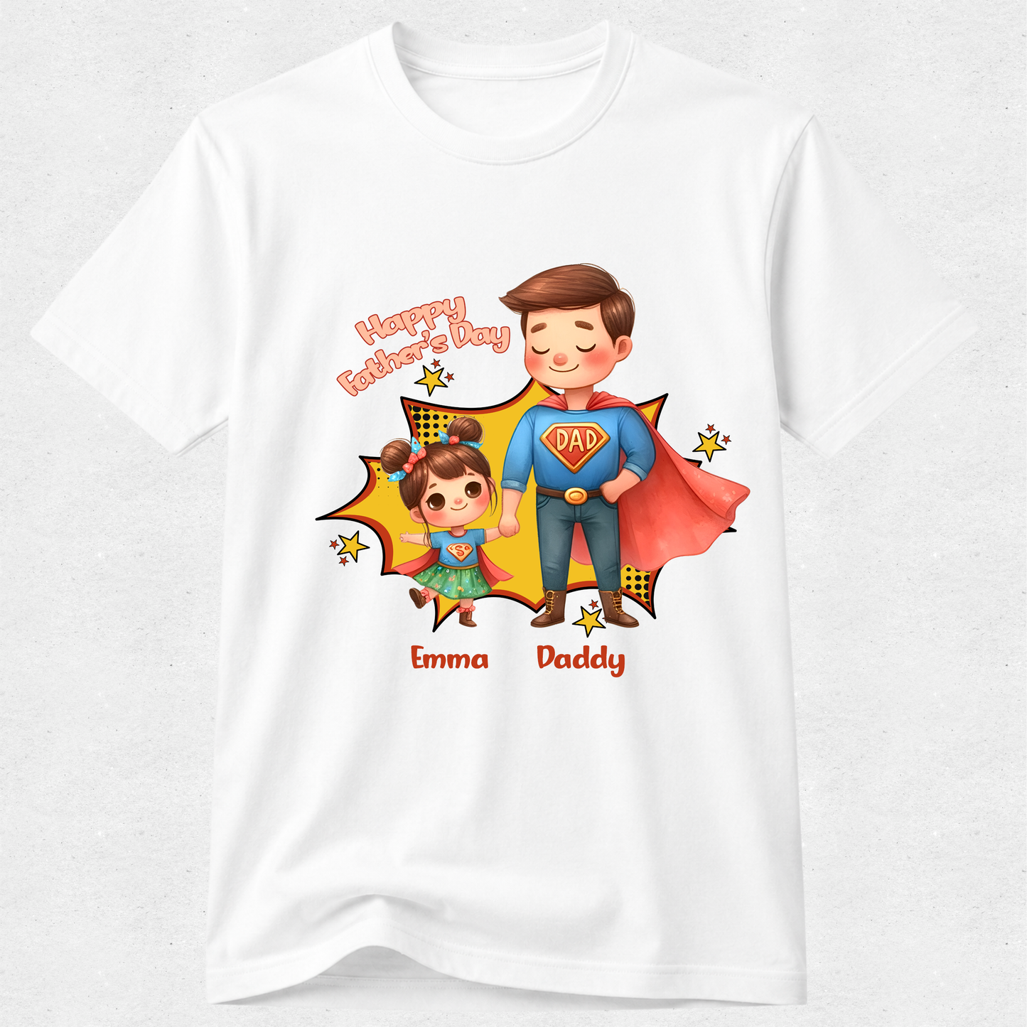 A white short-sleeve crewneck t-shirt featuring a colorful cartoon graphic of a father and daughter dressed as superheroes, with 'Happy Father's Day' text and the names 'Emma' and 'Daddy' printed below.