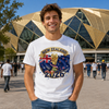 Man wearing a white t-shirt with New Zealand 2026 design in front of a large building.