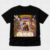 A black short-sleeve crewneck t-shirt featuring a colorful graphic print for 'Book Week' at 'Wizard Academy' about 'Henry'. The graphic shows a cartoon lion in a wizard outfit, a cat, a owl, a dragon, and a 'Can You Find?' word search grid at the bottom, displayed on a light gray textured background.