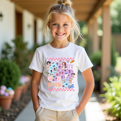 Young girl wearing a white t-shirt with a colorful design, standing outdoors.