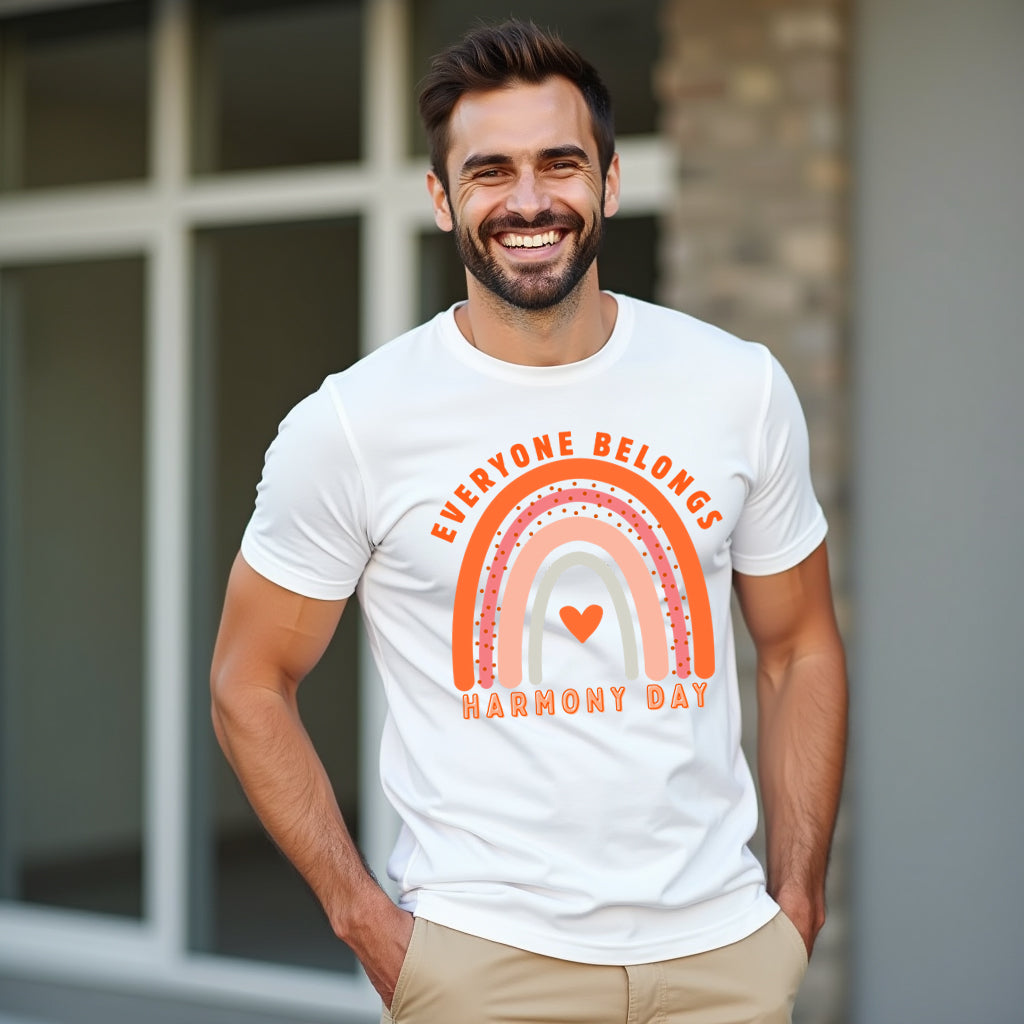 Man wearing a white t-shirt with a rainbow design and text, standing outdoors.