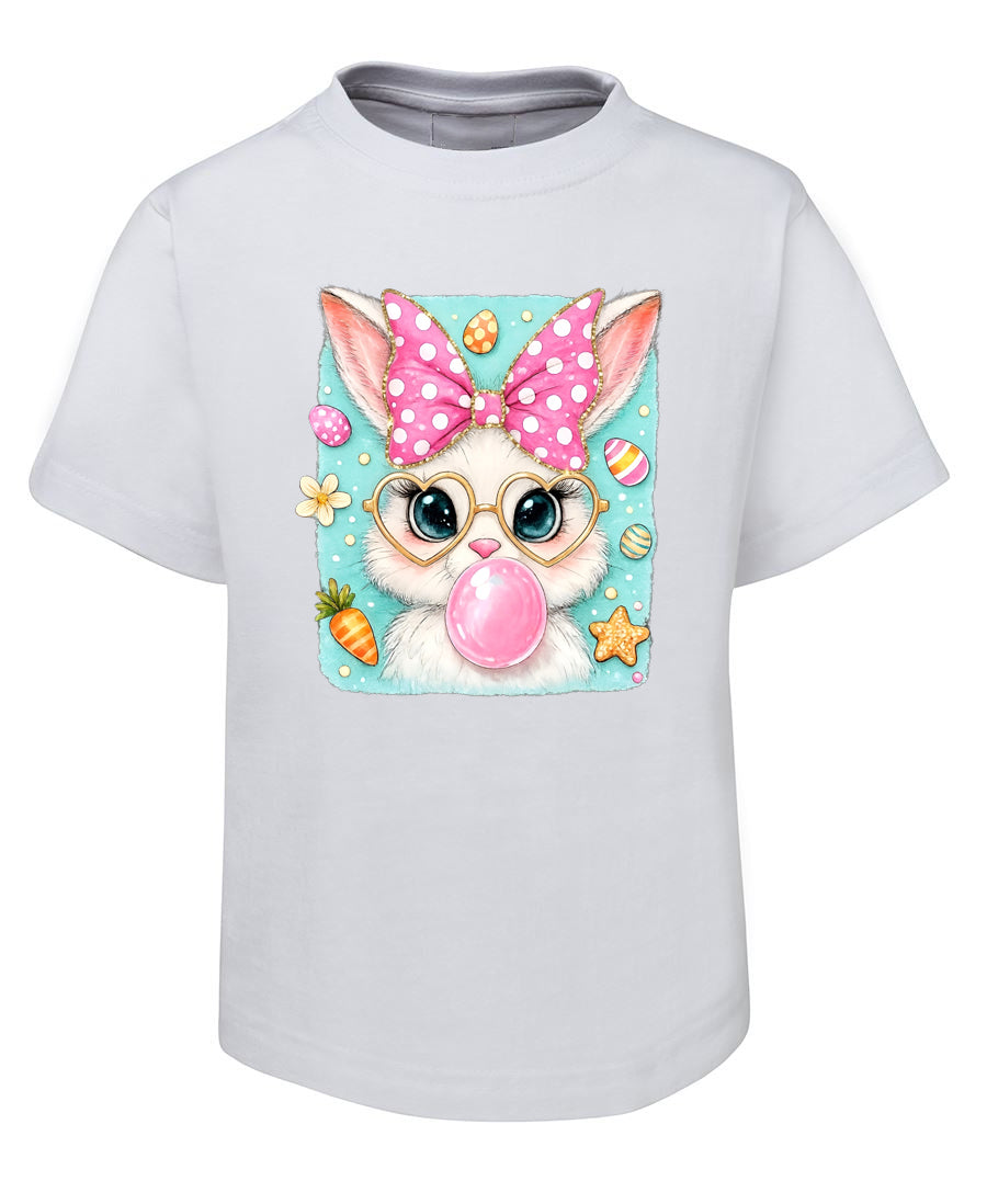 White t-shirt with a cartoon bunny wearing glasses and a polka dot bow, blowing a pink bubble, on a white background.