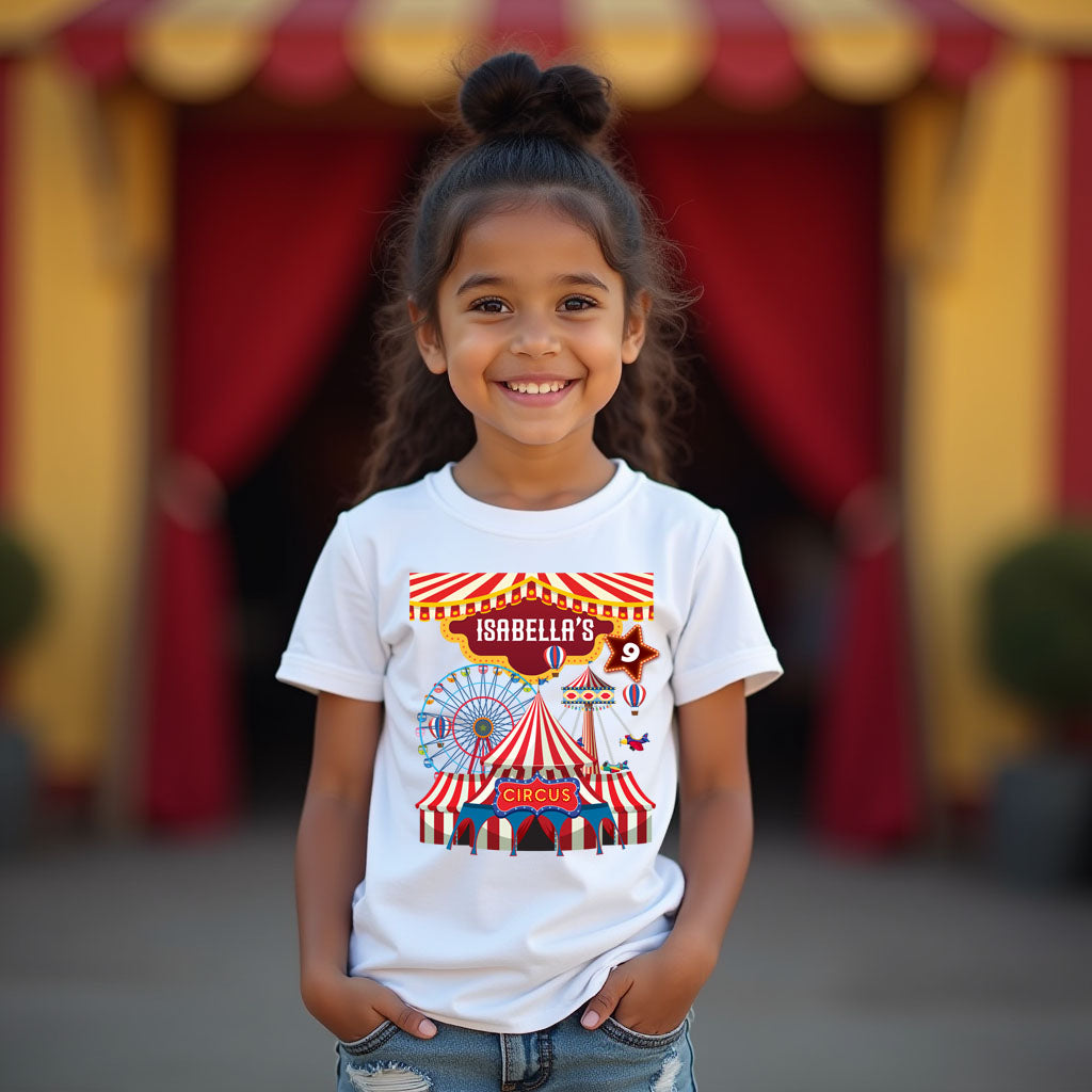 Young girl wearing a white t-shirt with a circus design in front of a red and yellow tent.