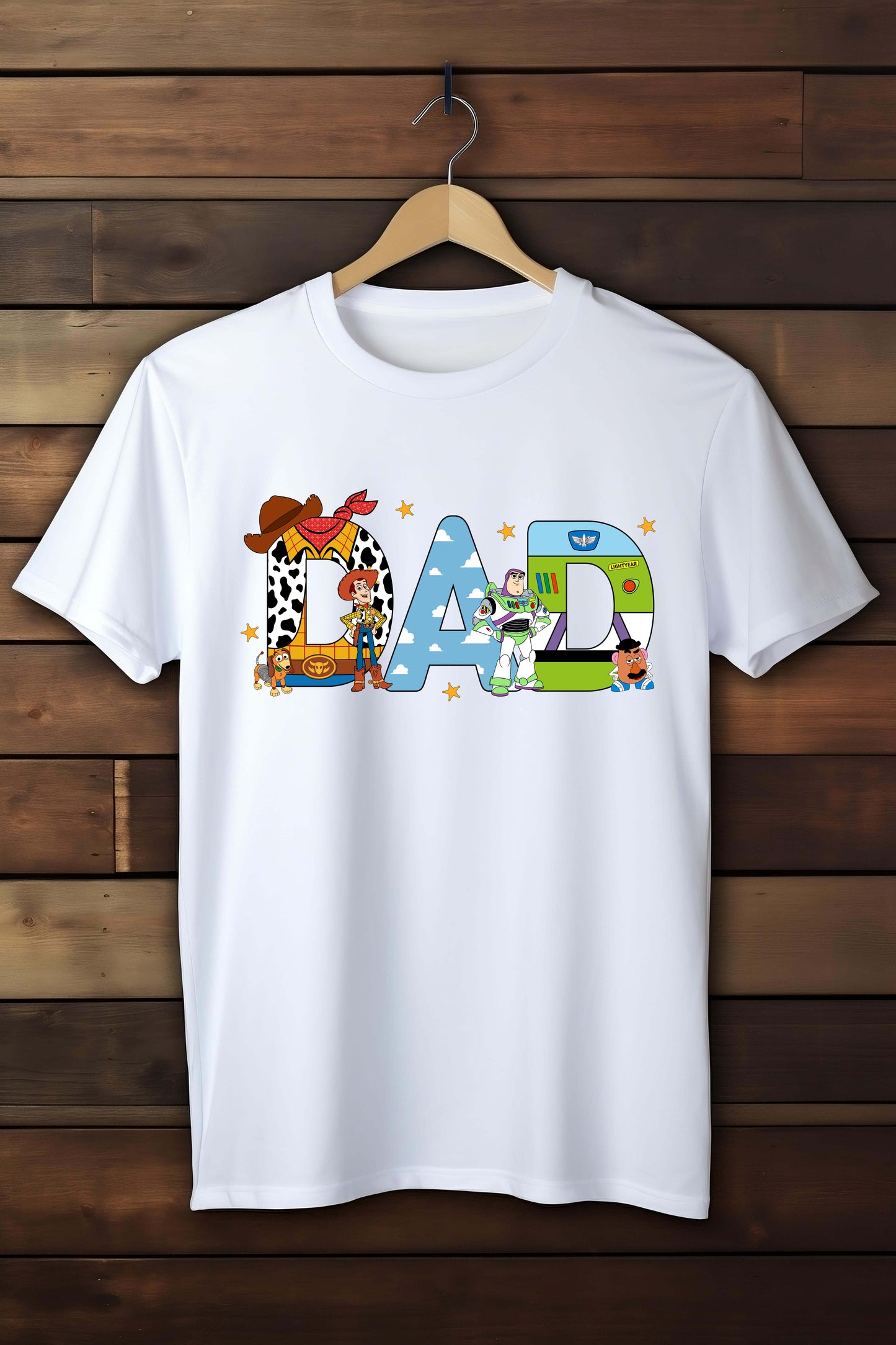 White t-shirt with colorful 'DAD' graphic on a wooden background