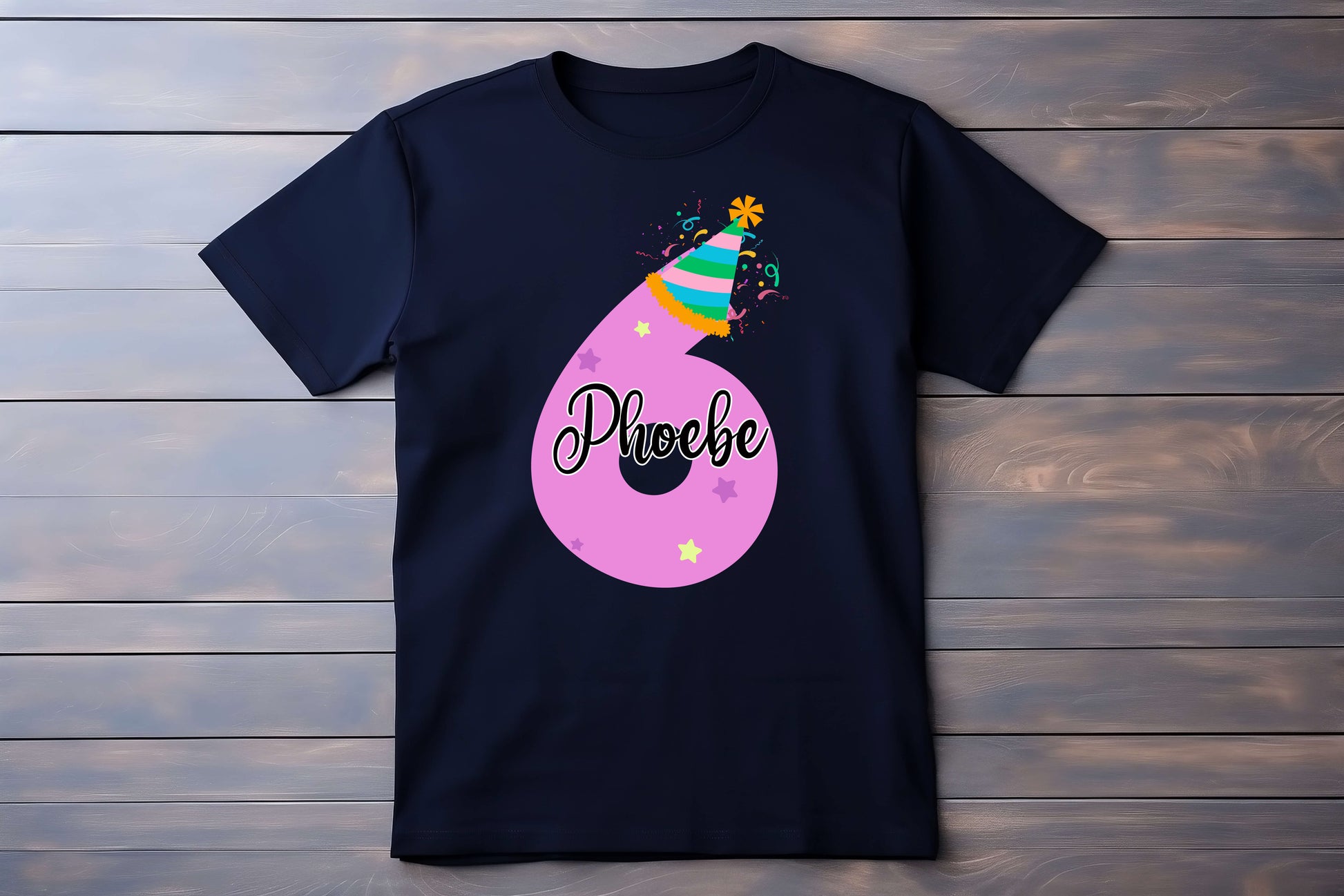 Black t-shirt with a colorful number '6' design and the name 'Phoebe' on a wooden background