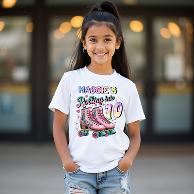 Young girl wearing a white t-shirt with colorful text and graphics, standing outdoors.
