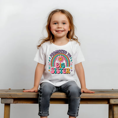 Young girl wearing bright and rainbow-inspired “Promoted to Big Sister” tee, perfect for family photos and gender reveals.