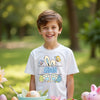 Child wearing a white t-shirt with colorful graphics and 'Aidan' text, standing outdoors.