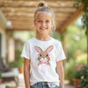 Young girl wearing a white t-shirt with a bunny design and name outdoors.