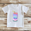 White t-shirt with a colorful 'Little Soda Pop' design on a wooden surface