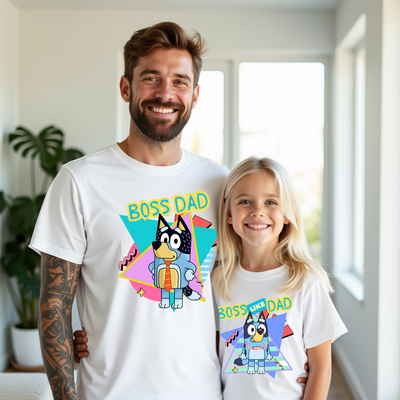 Man and young girl wearing matching 'Boss Dad' t-shirts indoors.
