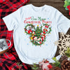 White t-shirt with Christmas-themed design on a wooden surface with festive decorations.