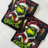 Flat lay of Just Waiting for Grinchmas Tshirt with Christmas decorations and accessories.
