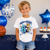 Boy celebrating his 7th birthday wearing colourful "I Was 6 Now I'm 7" birthday t-shirt with fun cartoon number design.